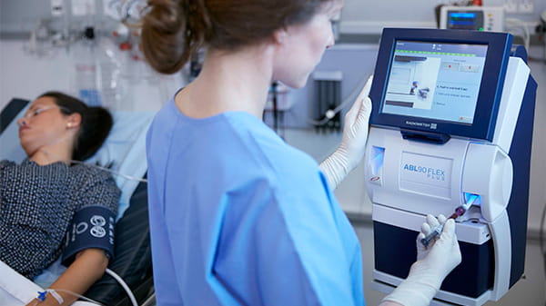 Pielęgniarka wykonująca analizę parametrów krytycznych na analizatorze ABL90 FLEX Plus firmy Radiometer